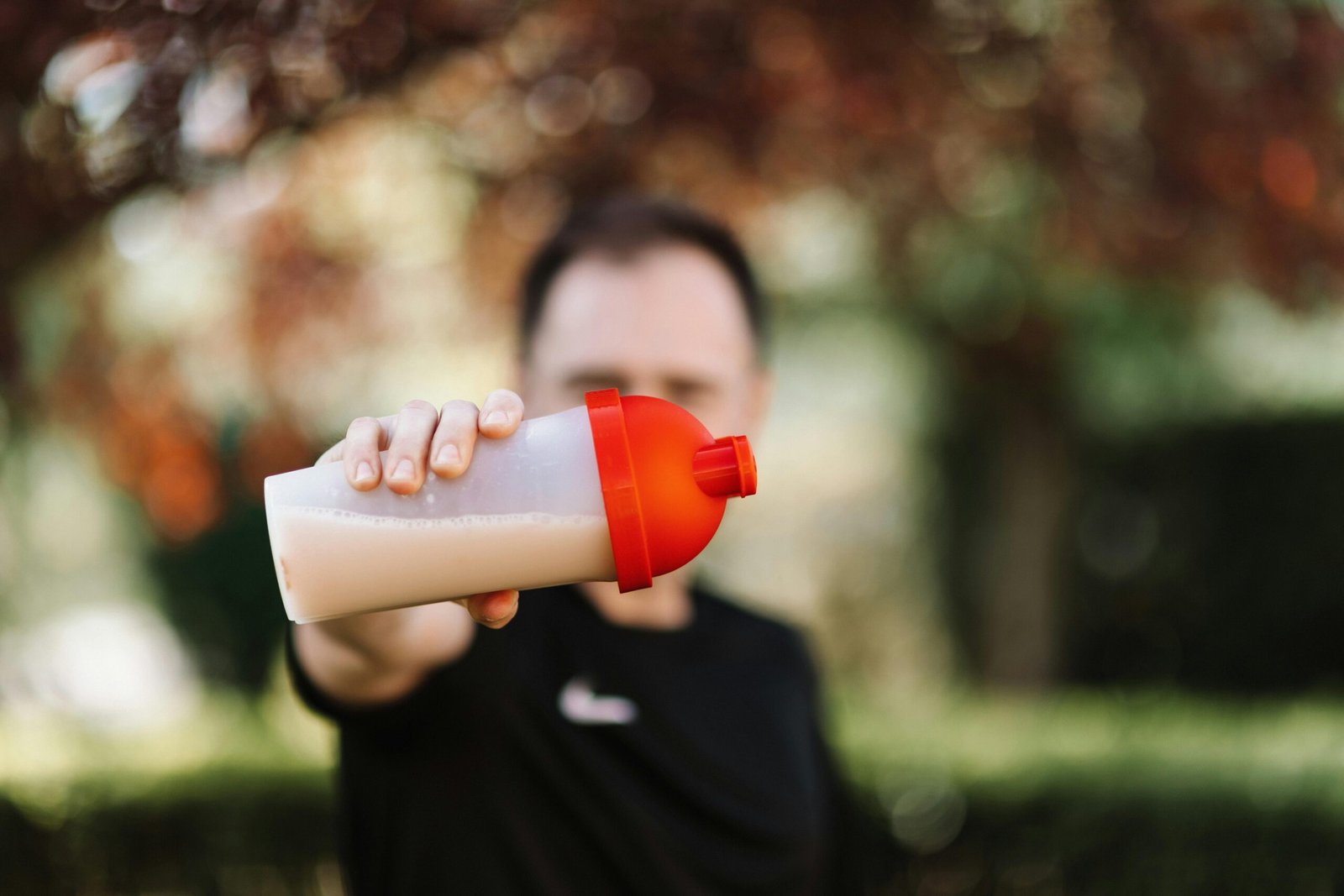 Protein shake bottle and supplement capsules representing fitness routine